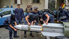 This handout picture released by the Italian police (Polizia di Stato) of Turin, on July 15, 2019, shows italian policemen carry an air-to-air missile, as part of a big cache of guns and ammunition that was seized by the Turin special police force, cal...