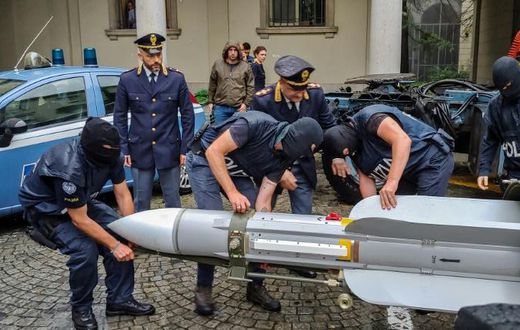 This handout picture released by the Italian police (Polizia di Stato) of Turin, on July 15, 2019, shows italian policemen carry an air-to-air missile, as part of a big cache of guns and ammunition that was seized by the Turin special police force, cal...