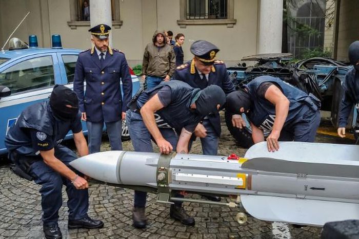 This handout picture released by the Italian police (Polizia di Stato) of Turin, on July 15, 2019, shows italian policemen carry an air-to-air missile, as part of a big cache of guns and ammunition that was seized by the Turin special police force, cal...