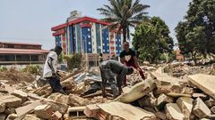 Des hommes récupèrent des métaux sur le chantier de démolition de la cité ministérielle à Conakry. © Matthias Raynal/RFI