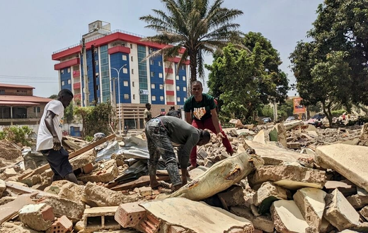 Des hommes récupèrent des métaux sur le chantier de démolition de la cité ministérielle à Conakry. © Matthias Raynal/RFI