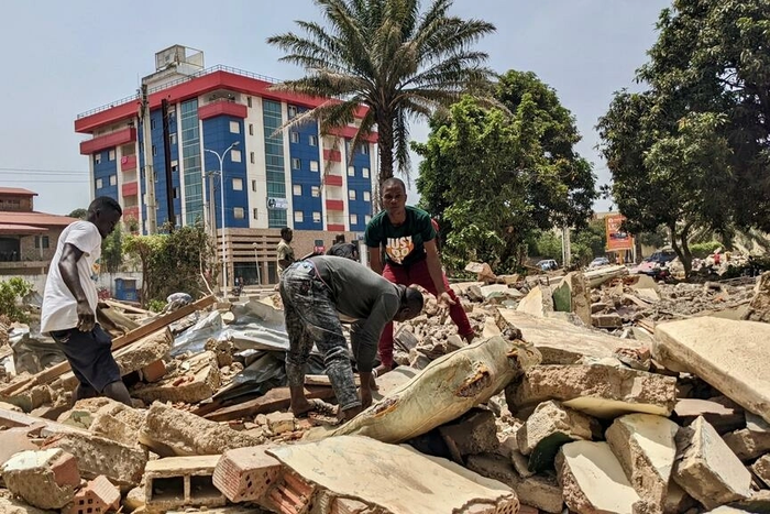 Des hommes récupèrent des métaux sur le chantier de démolition de la cité ministérielle à Conakry. © Matthias Raynal/RFI