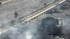 Soldat ukrainier passant à côté des débris d'un camion militaire dans la rue à Kiev - Samedi