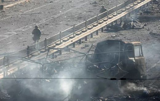Soldat ukrainier passant à côté des débris d'un camion militaire dans la rue à Kiev - Samedi