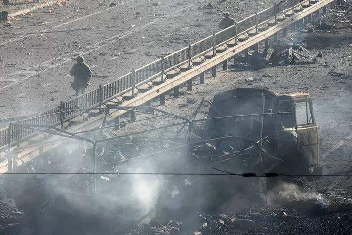 Soldat ukrainier passant à côté des débris d'un camion militaire dans la rue à Kiev - Samedi