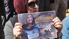 Une femme portant une affiche avec le visage de la journaliste assassinée — HAZEM BADER - AFP