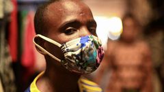 Eugene Amuri, a vendor at the Kimironko market wears a handmade "kitenge" cloth mask as he attempts to protect against the coronavirus disease (COVID-19), in Kigali, Rwanda March 17, 2020. (REUTERS/Maggie Andresen)
