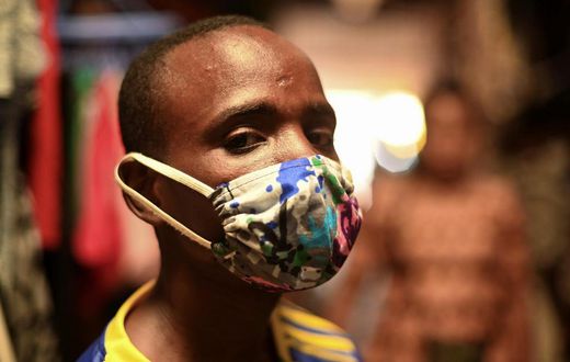 Eugene Amuri, a vendor at the Kimironko market wears a handmade "kitenge" cloth mask as he attempts to protect against the coronavirus disease (COVID-19), in Kigali, Rwanda March 17, 2020. (REUTERS/Maggie Andresen)
