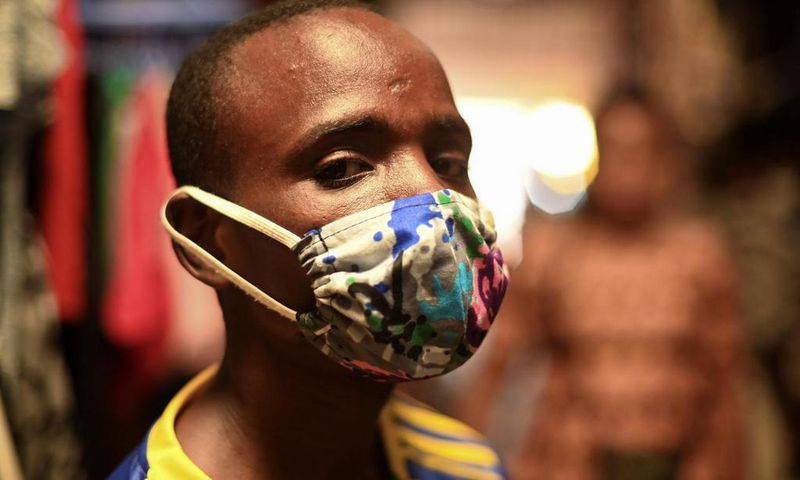 Eugene Amuri, a vendor at the Kimironko market wears a handmade "kitenge" cloth mask as he attempts to protect against the coronavirus disease (COVID-19), in Kigali, Rwanda March 17, 2020. (REUTERS/Maggie Andresen)