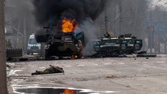 A Russian armored personnel carrier burns amid damaged and abandoned light utility vehicles after fighting in Kharkiv, Ukraine, Sunday, Feb. 27, 2022.