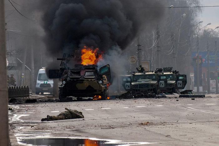 A Russian armored personnel carrier burns amid damaged and abandoned light utility vehicles after fighting in Kharkiv, Ukraine, Sunday, Feb. 27, 2022.