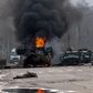 A Russian armored personnel carrier burns amid damaged and abandoned light utility vehicles after fighting in Kharkiv, Ukraine, Sunday, Feb. 27, 2022.