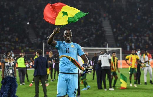 Edouard Mendy waves a Senegalese flag as he celebrates winning the Cup of Nations in Yaounde