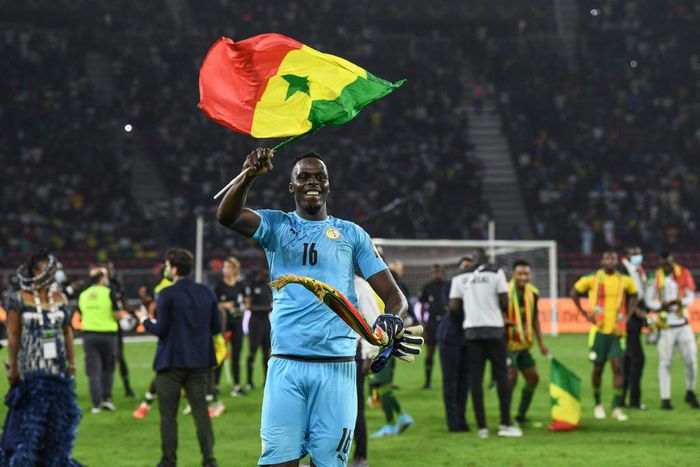 Edouard Mendy waves a Senegalese flag as he celebrates winning the Cup of Nations in Yaounde