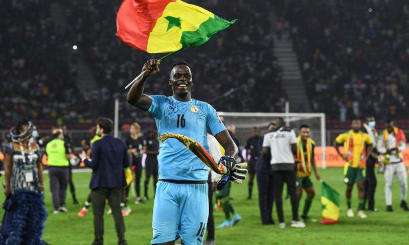Edouard Mendy waves a Senegalese flag as he celebrates winning the Cup of Nations in Yaounde