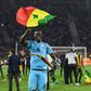 Edouard Mendy waves a Senegalese flag as he celebrates winning the Cup of Nations in Yaounde