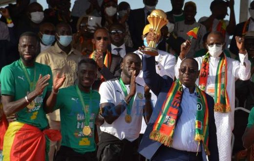Le président Macky Sall brandit fièrement le trophée de champion d'Afrique