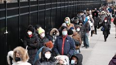 People wait in line as city workers hand out take-home COVID-19 tests in lower Manhattan on December 23, 2021.