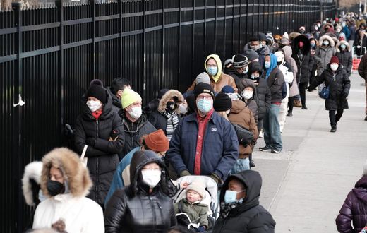 People wait in line as city workers hand out take-home COVID-19 tests in lower Manhattan on December 23, 2021.