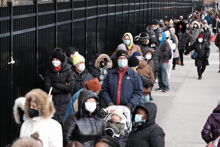 People wait in line as city workers hand out take-home COVID-19 tests in lower Manhattan on December 23, 2021.