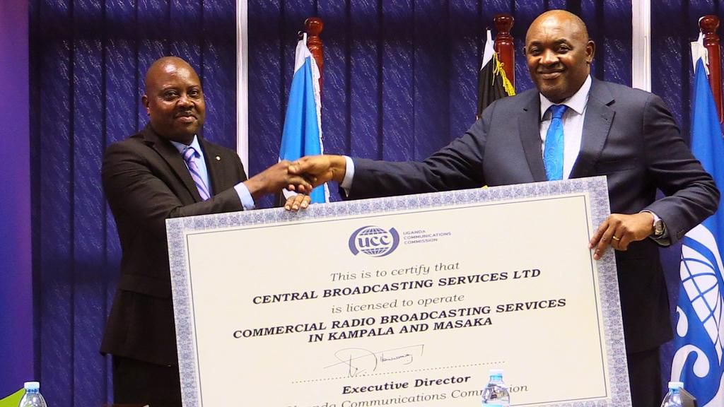 Minister Baryomunsi handed the license to CBS FM Managing Director Michael Kawooya