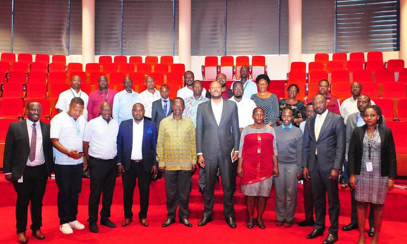 UIA Director General Robert Mukiza (4R) and Daudi Migereko (4L) with Kikuubo traders at UIA Head Office in Kampala