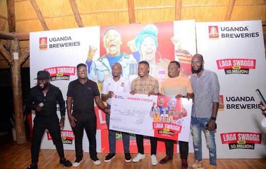 (L) Hillary Baguma- UBL Brand Manager Uganda Waragi and the Marketing Manager Spirirts-Robert Nsibirwa hand over dummy cheque to the first three Laga Swaga promo winners at the promotion launch
