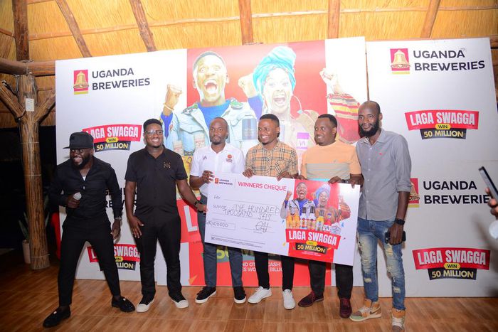 (L) Hillary Baguma- UBL Brand Manager Uganda Waragi and the Marketing Manager Spirirts-Robert Nsibirwa hand over dummy cheque to the first three Laga Swaga promo winners at the promotion launch