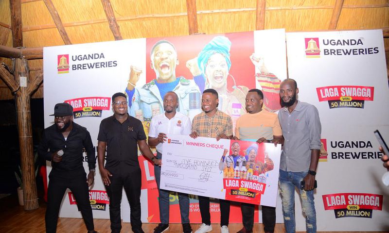 (L) Hillary Baguma- UBL Brand Manager Uganda Waragi and the Marketing Manager Spirirts-Robert Nsibirwa hand over dummy cheque to the first three Laga Swaga promo winners at the promotion launch