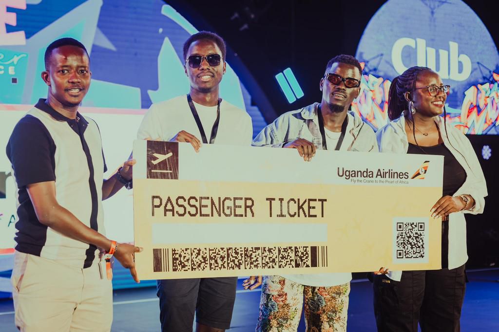 Eyo Mackus, second from right, receiving a dummy ticket from Uganda Airlines officials