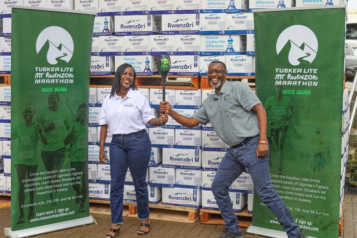 Pearl Nimusiima, the Public Affairs and Communications Manager of CCBU and Amos Wekesa, the Tusker Lite Mt.Rwenzori Marathon  Team Leader  pose for a photo during the Launch of the CCBU Mt. Rwenzori partnership