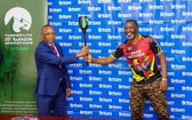 Amos Wekesa hands over the marathon torch to Allan Mafabi, the Britam CEO