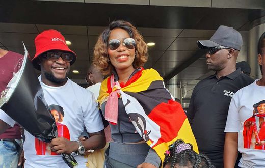 Ritah Kaggwa on arrival draped with Uganda flag