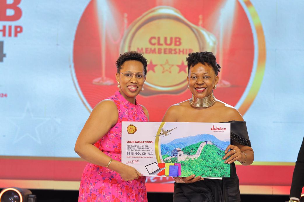 Jubilee Life Insurance COO Dorcus Kuhimbisa (L) awards Diana Ndege Ssempasa one of the top winners on the night