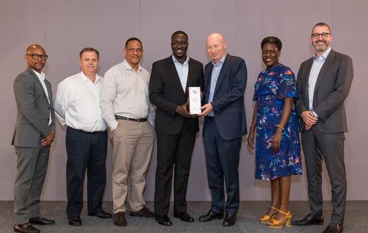 Vivo Energy Group CEO Stan Mittelman (3R), presents the Vivo Award to the Uganda Team led by the MD, Joanita Mukasa Menya (2R) and the officials at the conference recently.