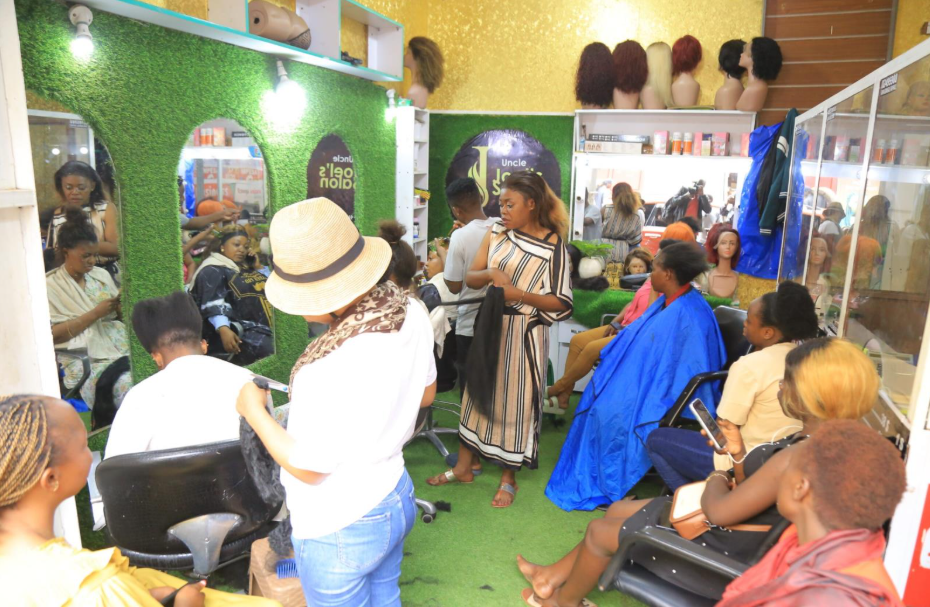 Mrs. Bongo Honoring (center), preparing to braid a client’s hair, at Uncle Joel’s Salon