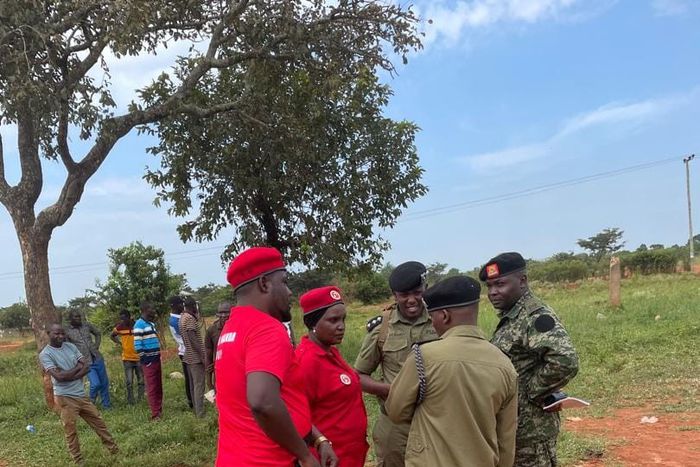 NUP supporters (in red) conferring with Uganda Police.