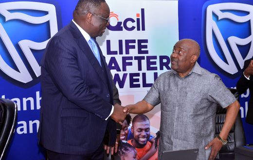 Stanbic Bank Chief Executive Mumba Kalifungwa interacts with Quality Chemicals Managing Director Mr. Katongole Emmanuel during the partnership signing event in Kampala