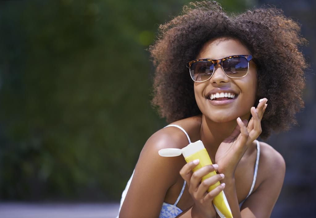 Woman applying sunscreen (transfercancun-airport)