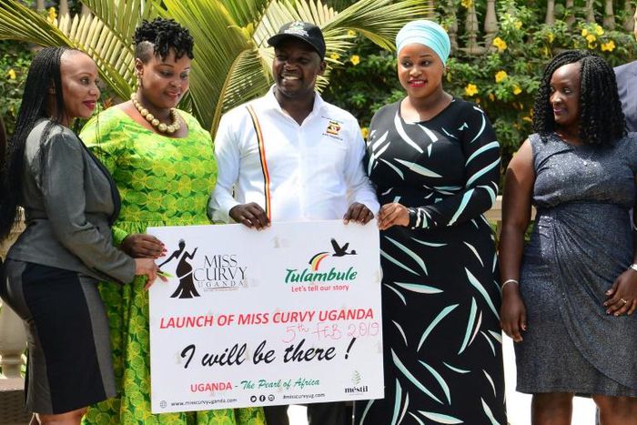 Uganda's Tourism Minister Godfrey Kiwanda posed with women during the launch of the Miss Curvy beauty contest in the capital Kampala