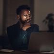 Shot of a young businessman using a laptop during a late night at work