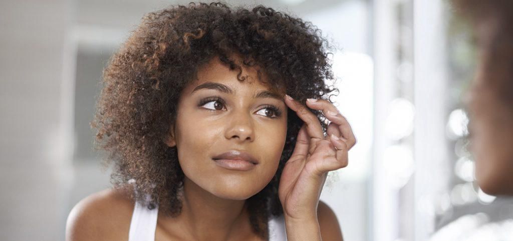 Woman applying vaseline on her eyebrows