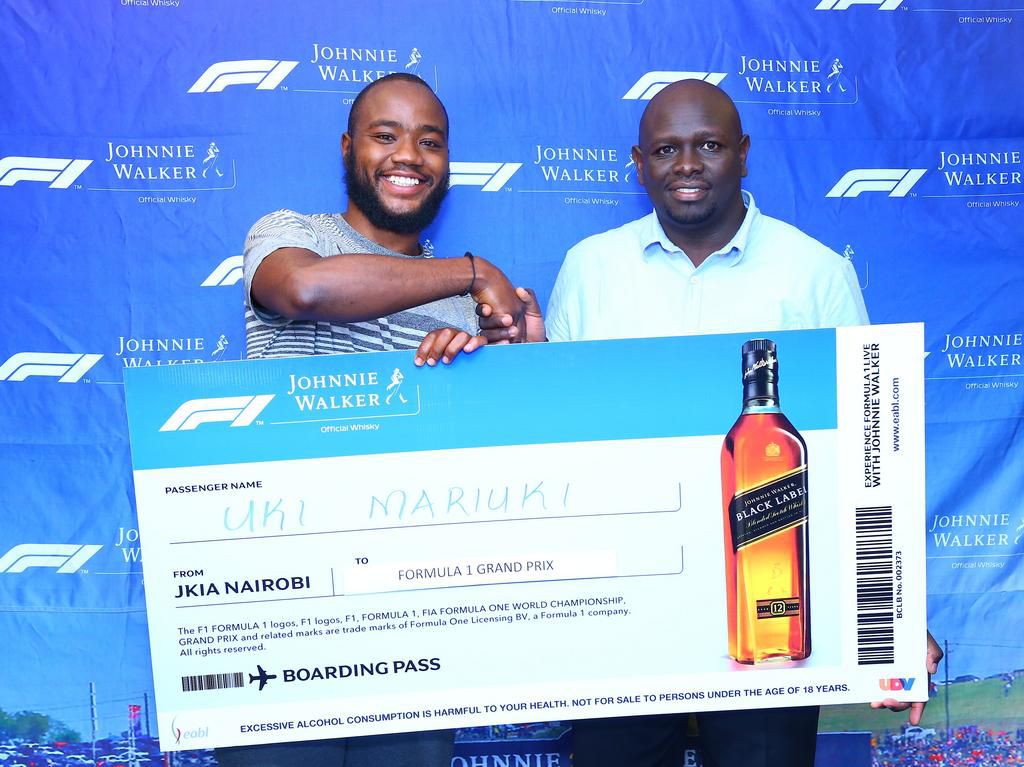 Uki Mariuki a Grand Prix winner from Nairobi receives his dummy air ticket from Joel Kamau, Head of Emerging Beer at KBL. Mr Mariuki is one of the lucky winners travelling to Azerbaijan Grand Prix through Experience Formula 1 with Johnnie Walker promot...