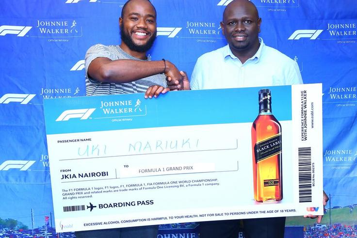 Uki Mariuki a Grand Prix winner from Nairobi receives his dummy air ticket from Joel Kamau, Head of Emerging Beer at KBL. Mr Mariuki is one of the lucky winners travelling to Azerbaijan Grand Prix through Experience Formula 1 with Johnnie Walker promot...