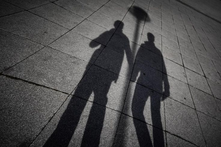 A shadow of two men holding hands (Unspalsh)