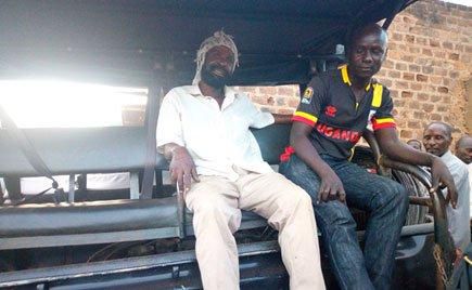 Paul Kiveyiganga, on the left, owner of the scrap shop