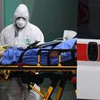 Medical workers stretch a patient from an Italian Red Cross ambulance into an intensive care unit set up in a sports center outside the San Raffaele hospital in Milan, on March 23, 2020 during the COVID-19 new coronavirus pandemic. (Photo by Miguel MED...