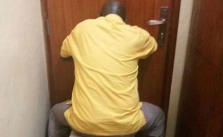 Mr Abiriga hides from cameras inside court. (Photo by Betty Ndagire)