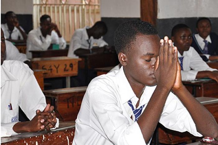A student praying in an examination room