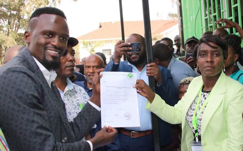 Mariga receiving clearence certificate from IEBC's Beatrice Muli